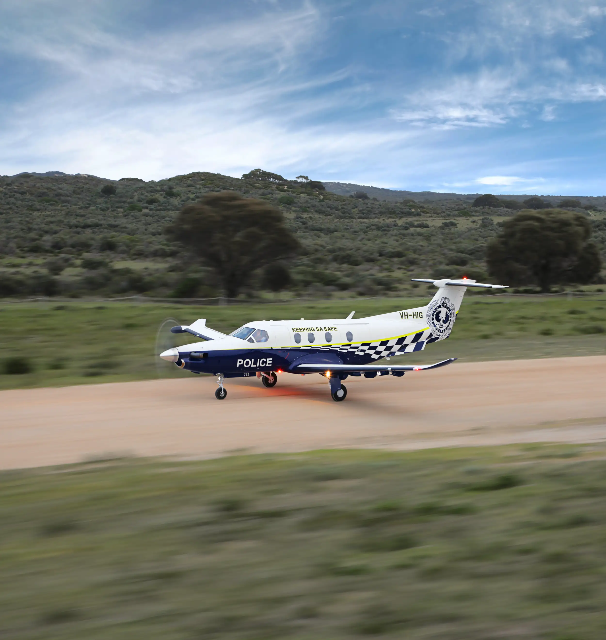 A PC-12 Spectre of the South Australia Police lands on natural ground.