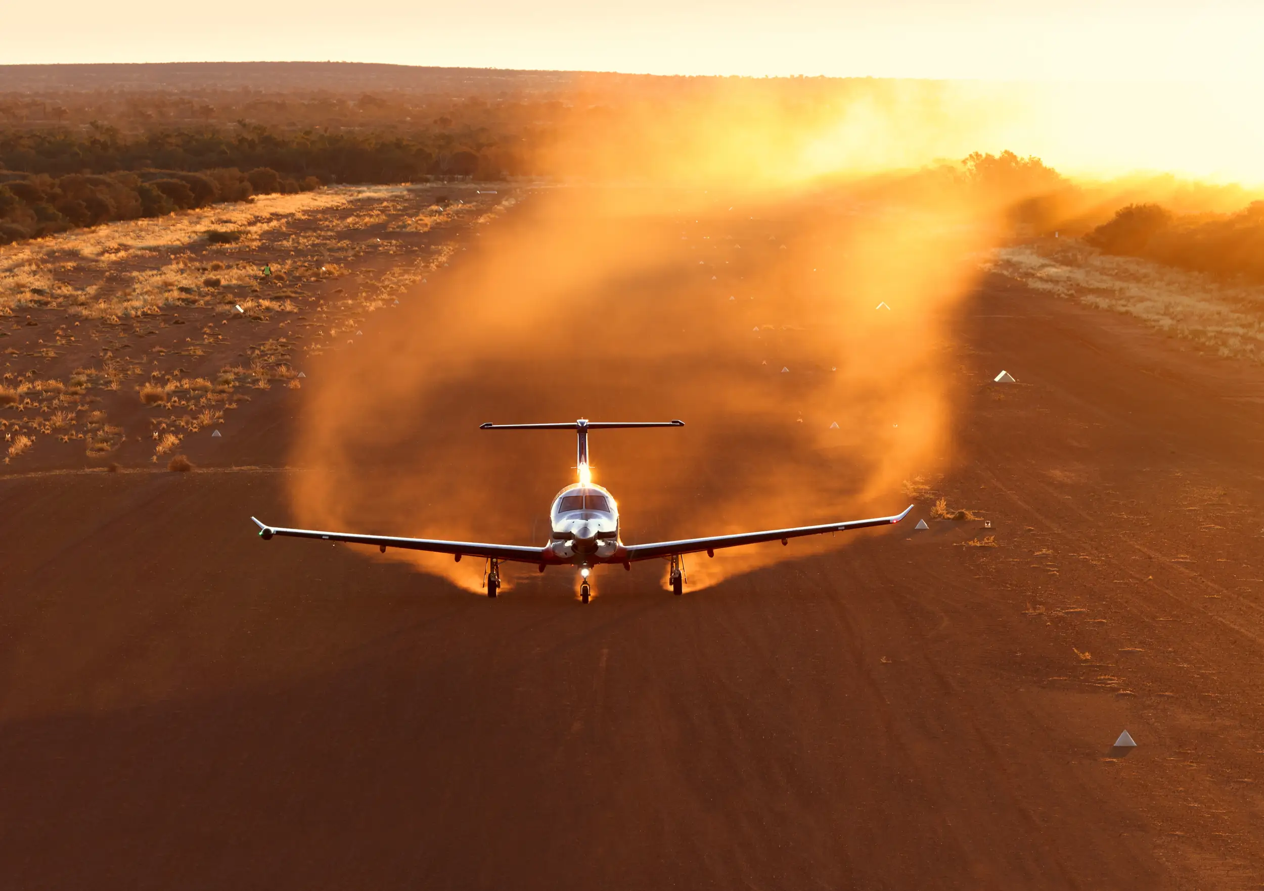 A PC-12 RFDS takes off from a dusty runway